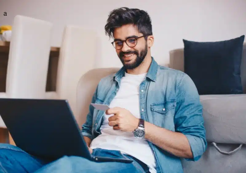 How Can You Order Glasses Online With a U.S. Prescription? A man using a laptop and credit card, likely making an online purchase, demonstrating the process of ordering glasses online with a U.S. prescription.