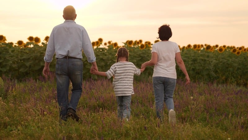 Parents walking hand in hand with children, symbolizing family support, trust, and emotional security during difficult conversations about addiction.