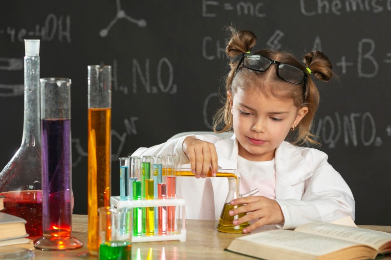 Child doing a science experiment with test tubes, colorful liquids, and a chemistry setup.