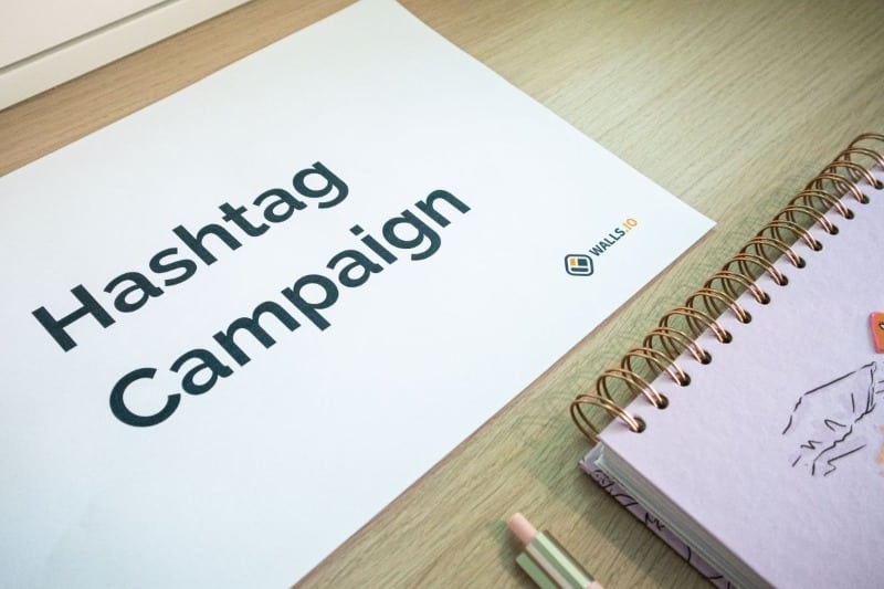 Hashtag campaign planning sheet beside a notebook for a Lead Generation engagement strategy.