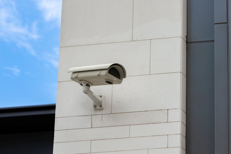 Emerging Trends in Business Security Camera Systems Wall-mounted security camera on a commercial building exterior for Business Security monitoring.