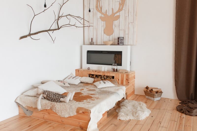 Farmhouse Style Ideas for Creating a Relaxed Home Atmosphere Farmhouse style bedroom with a rustic wood bed, natural textures, fireplace, and warm neutral decor.