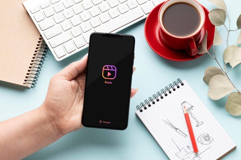 Proven Strategies to Boost Your Short-Form Video Engagement and Visibility Hand holding a smartphone with Instagram Reels open, representing short-form video content creation and social media engagement.